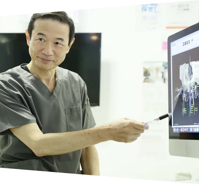 CT画像を見ながら治療計画を説明する歯科医師